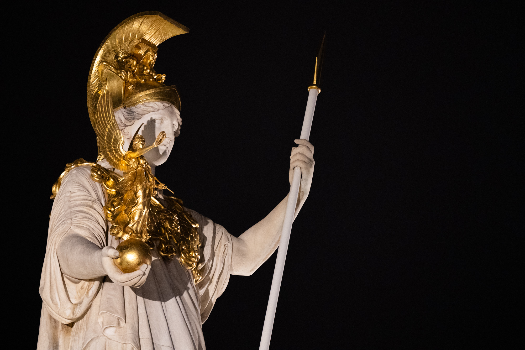 Athena in a gilt helm holding a spear, against a black ground.